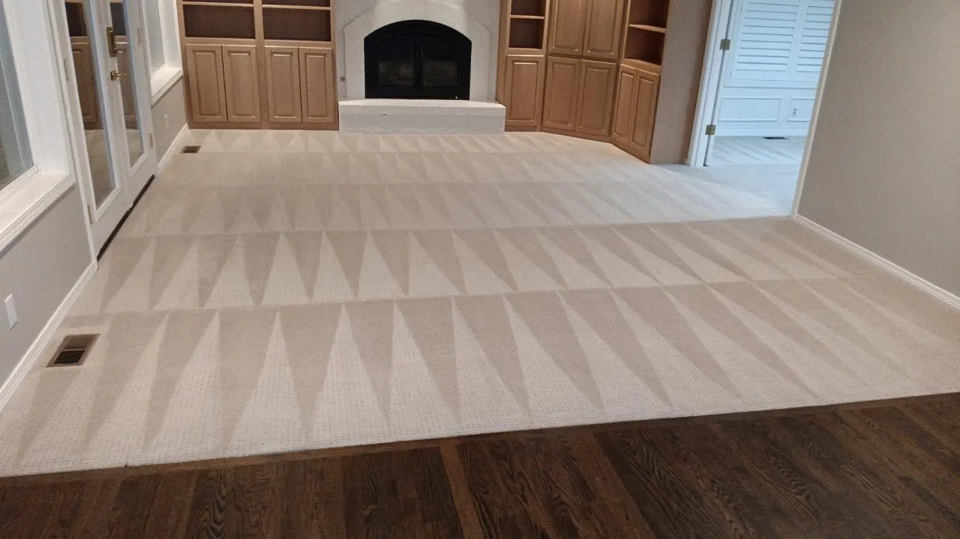Freshly cleaned cream carpet with wand pattern in a living room with a white brick fireplace and oak built-ins