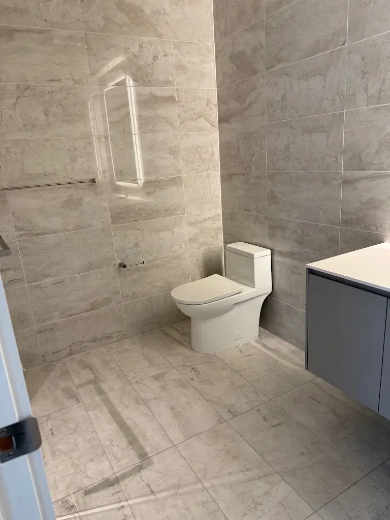 Large-format marble-look tile bathroom floor and walls, cleaned
